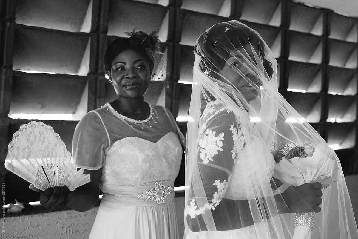 An African bride and her bridesmaid look a little nervous as they wait to enter the church