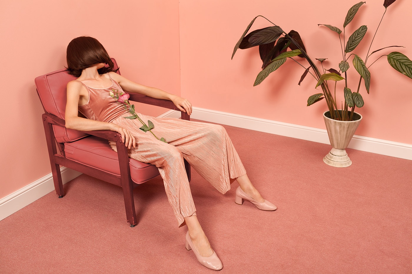 Woman Sitting On An Armchair In A Pink Room