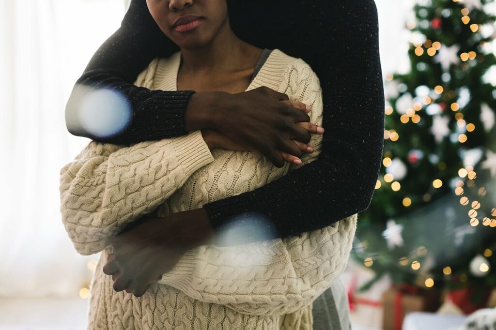 Closeup Portrait Of Multiethnic Couple Embracing Together At Home. Christmas Time.