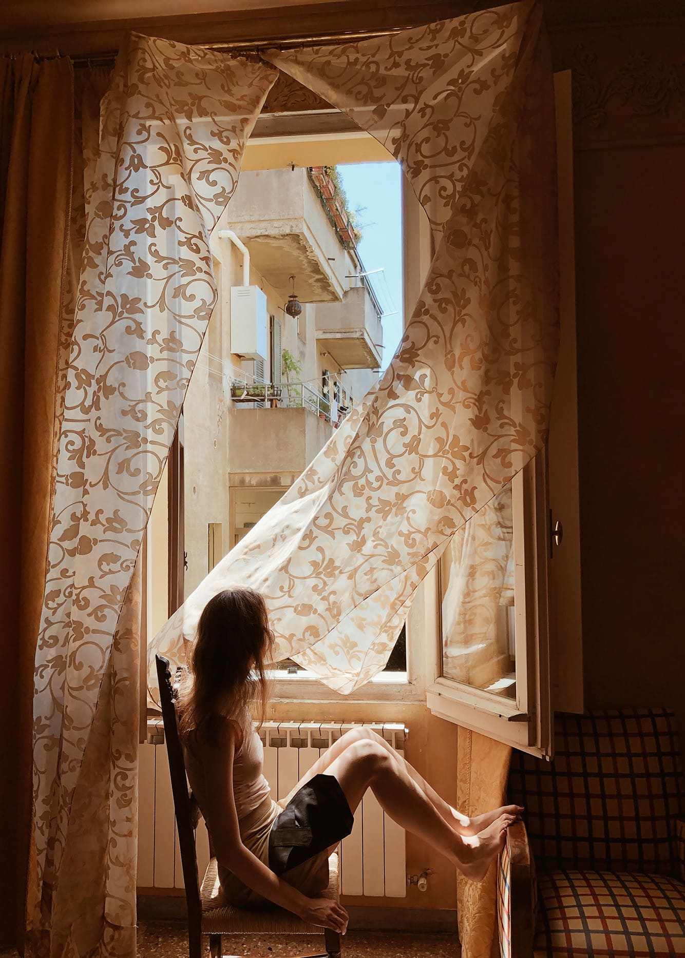 A Woman Sitting In Front Of Window