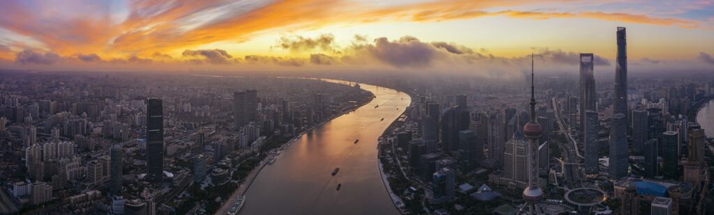 The landmarks of Shanghai's urban landmarks are dazzling under the reflection of the sunset, and the colors of the sky are reflected on the waters of the Huangpu River. The panorama taken by the aerial camera shows the style of the modern metropolis.