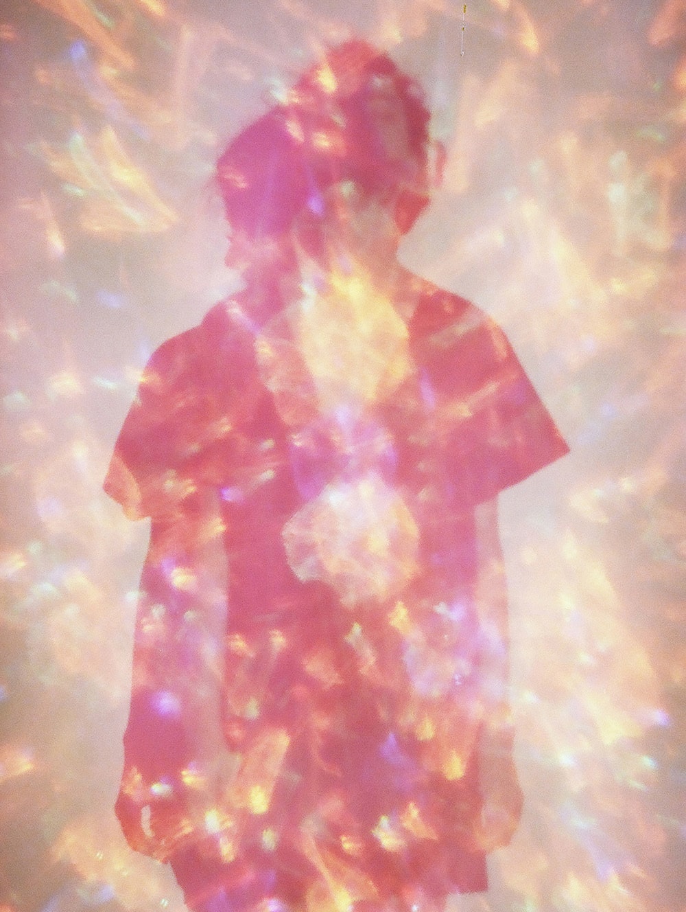 Back view of a woman. Double exposure 35 mm film shot. Pink sparkling background.