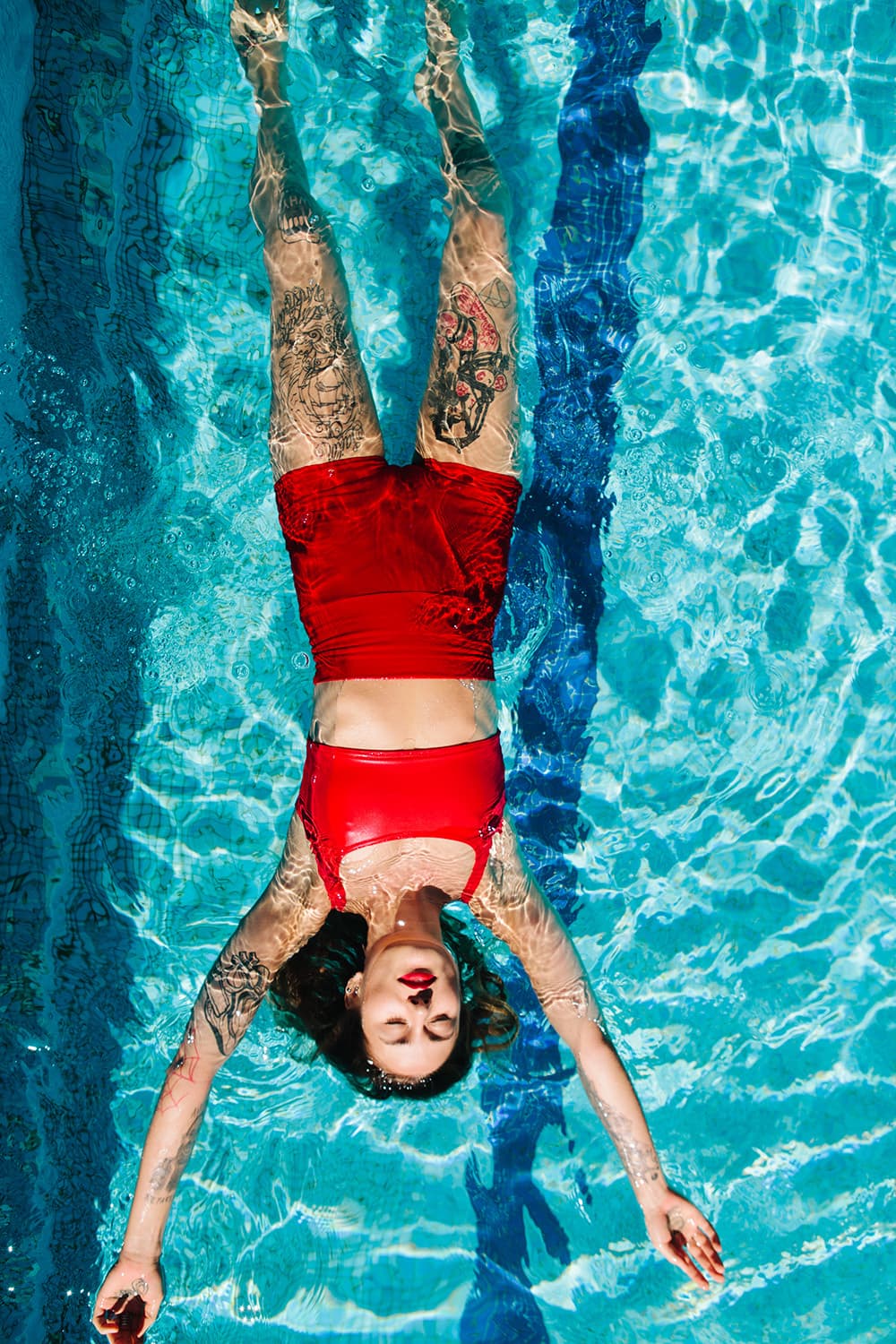 Tattooed Woman Floating In Pool