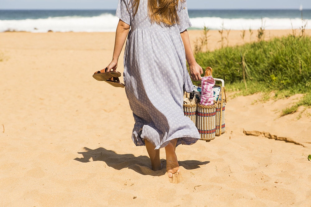 Woman Carrying A Picnic Basket At The Beach