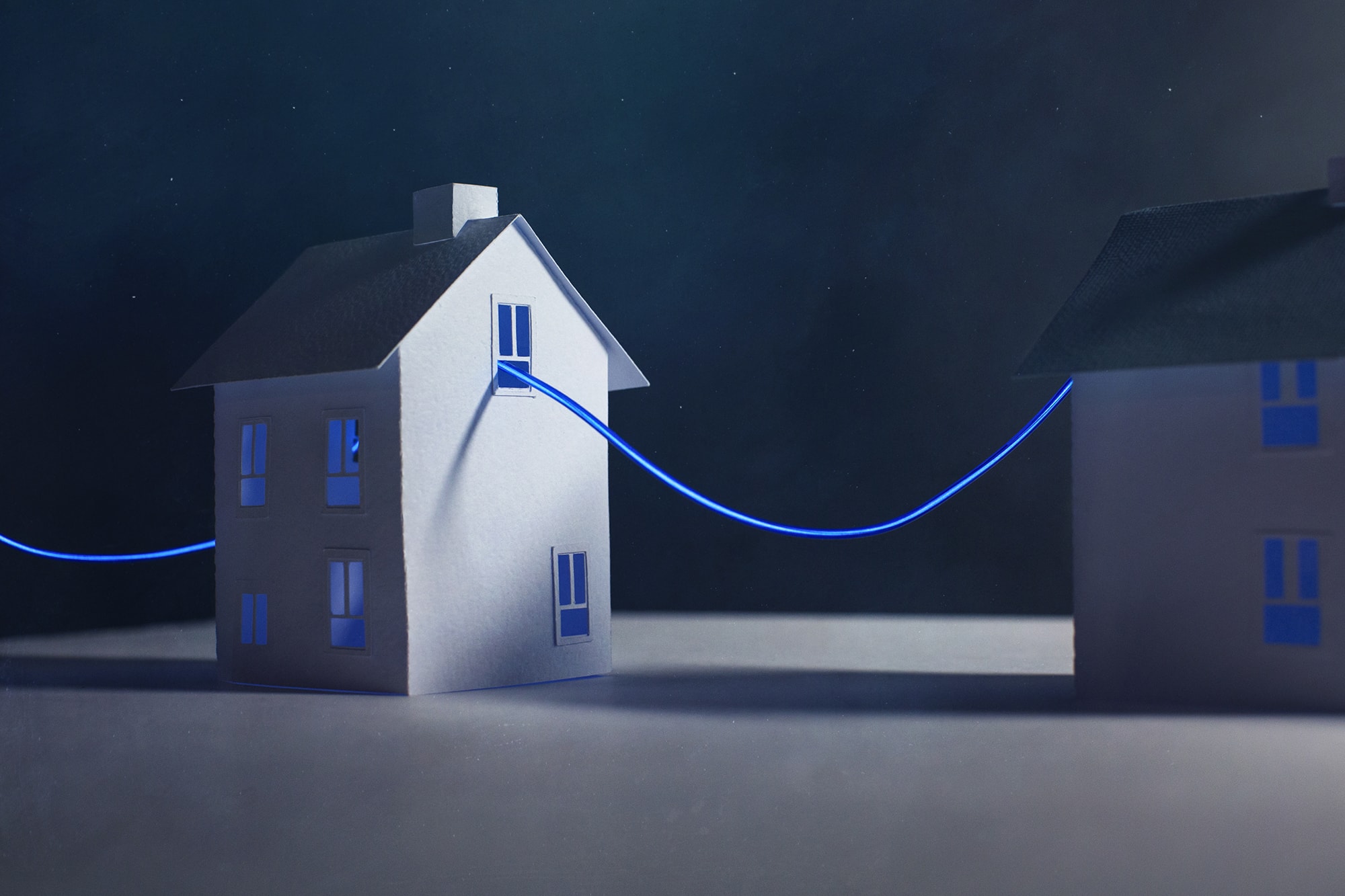 A neon cable travels from one paper home to the next