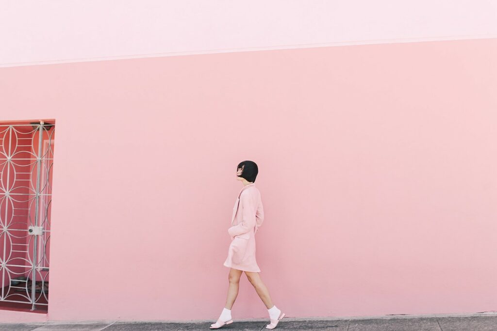 Girl in pink poses outside of house