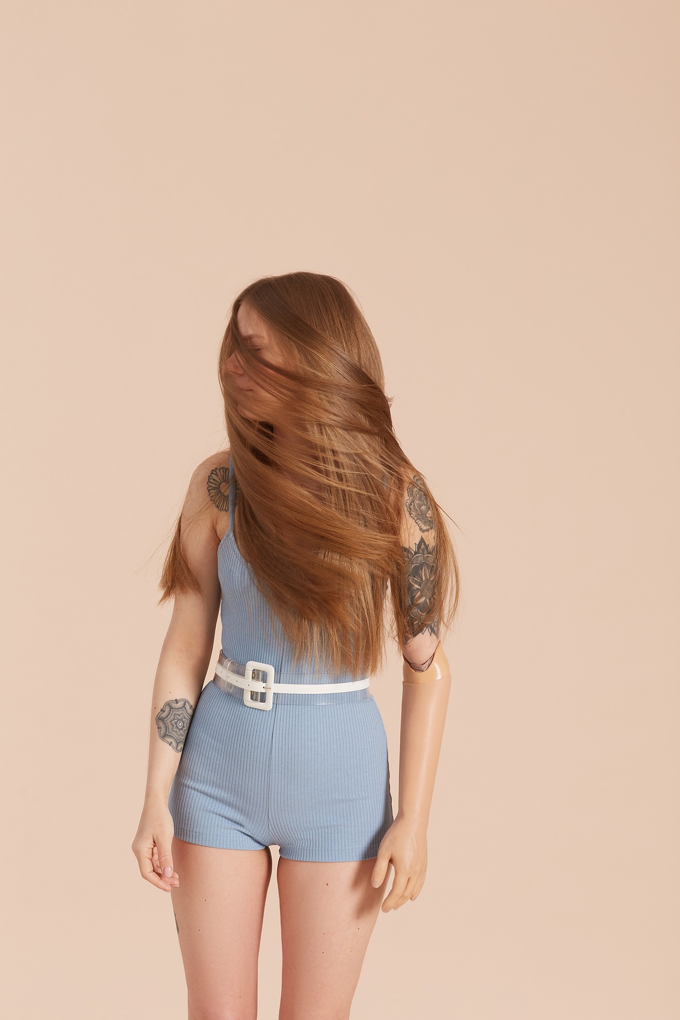 Disabled girl with beautiful long hair wearing blue bodysuit shaking her head