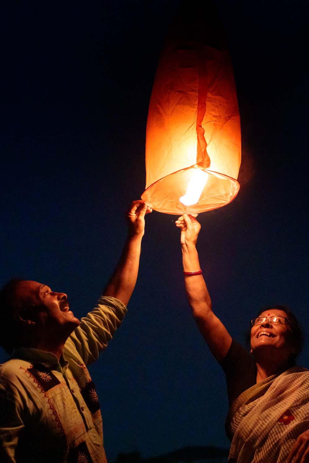 Senior Couple Releasing Sky Lantern At Evening