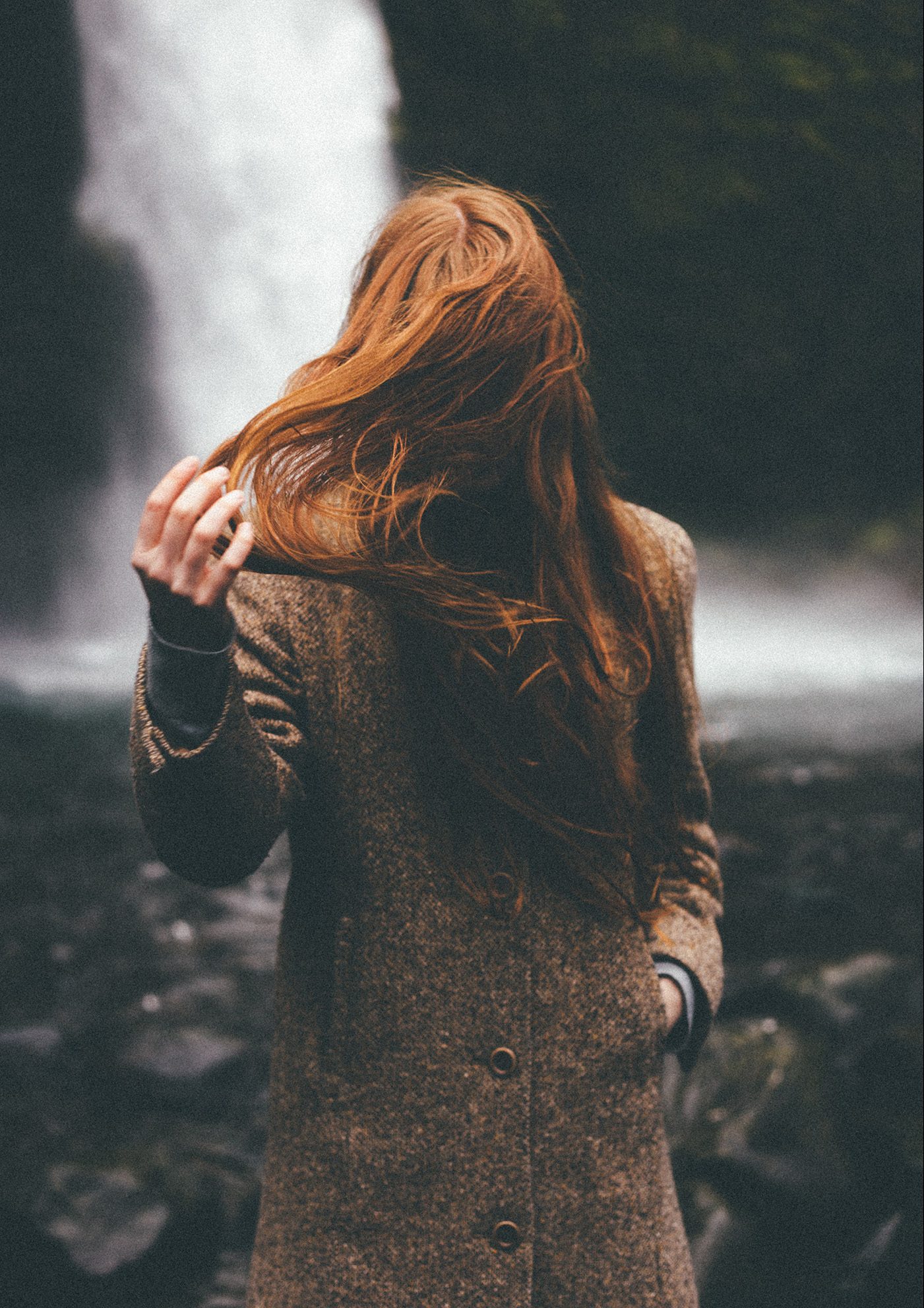 Redhead Standing By Waterfall