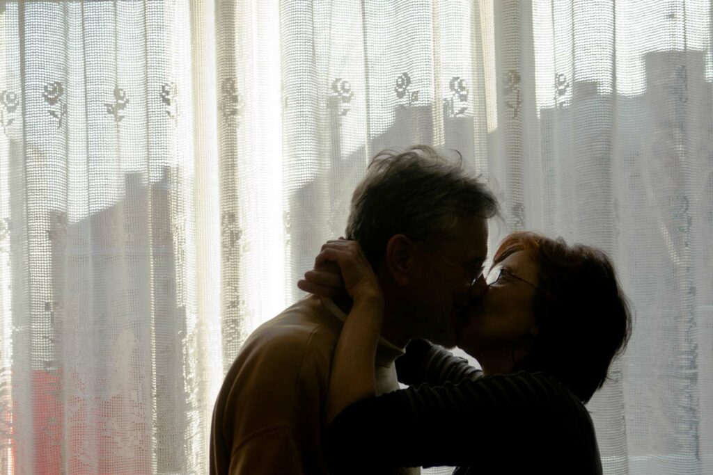 Senior couple kissing in front of the window Senior Couple In Love