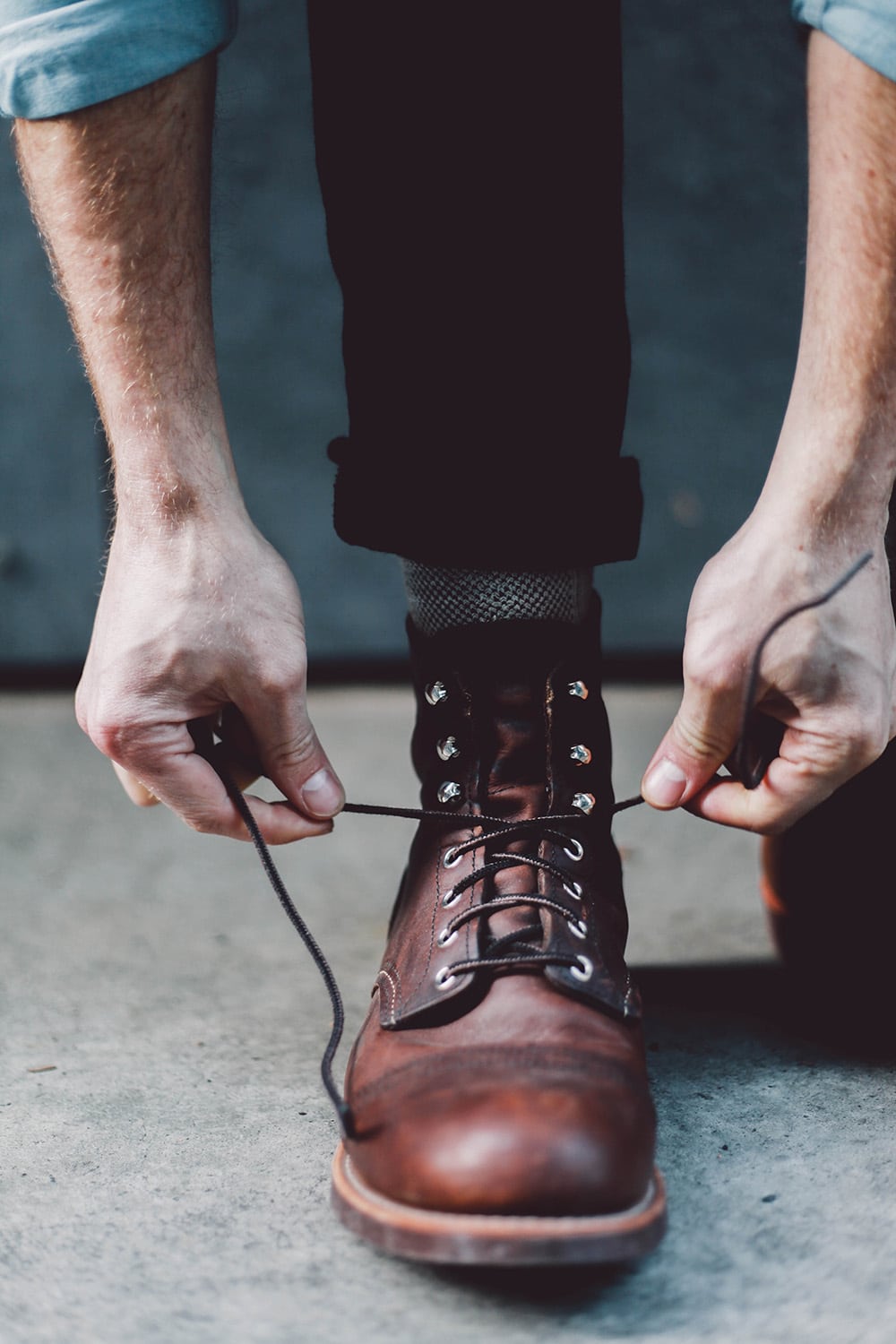 Male Tying Boot Laces Outdoors