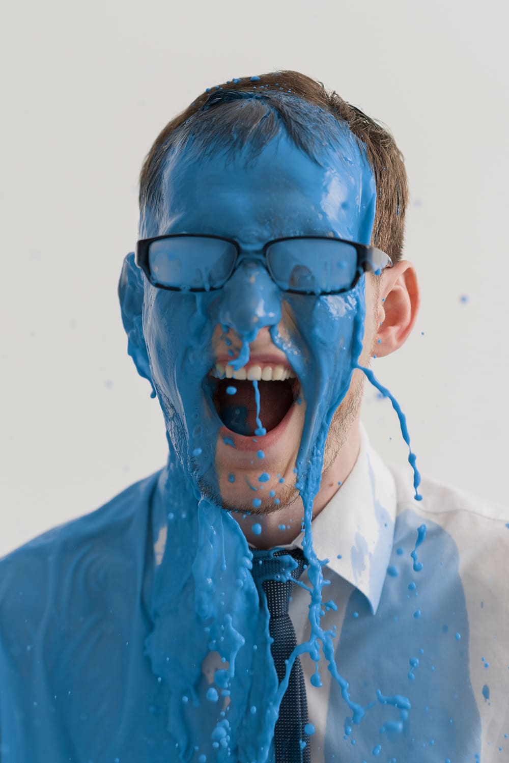Businessman colored with blue paint closeup portrait