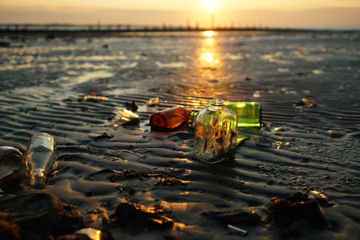 Sunset Rays Passing Through Old Glass Bottles On The Beach