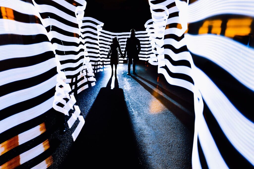 Silhouette Of Couple Standing In Light Neon Corridor