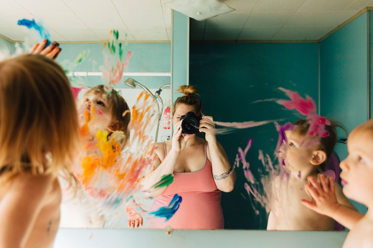 Mother Taking Picture Of Kids Painting On Bathroom Mirror