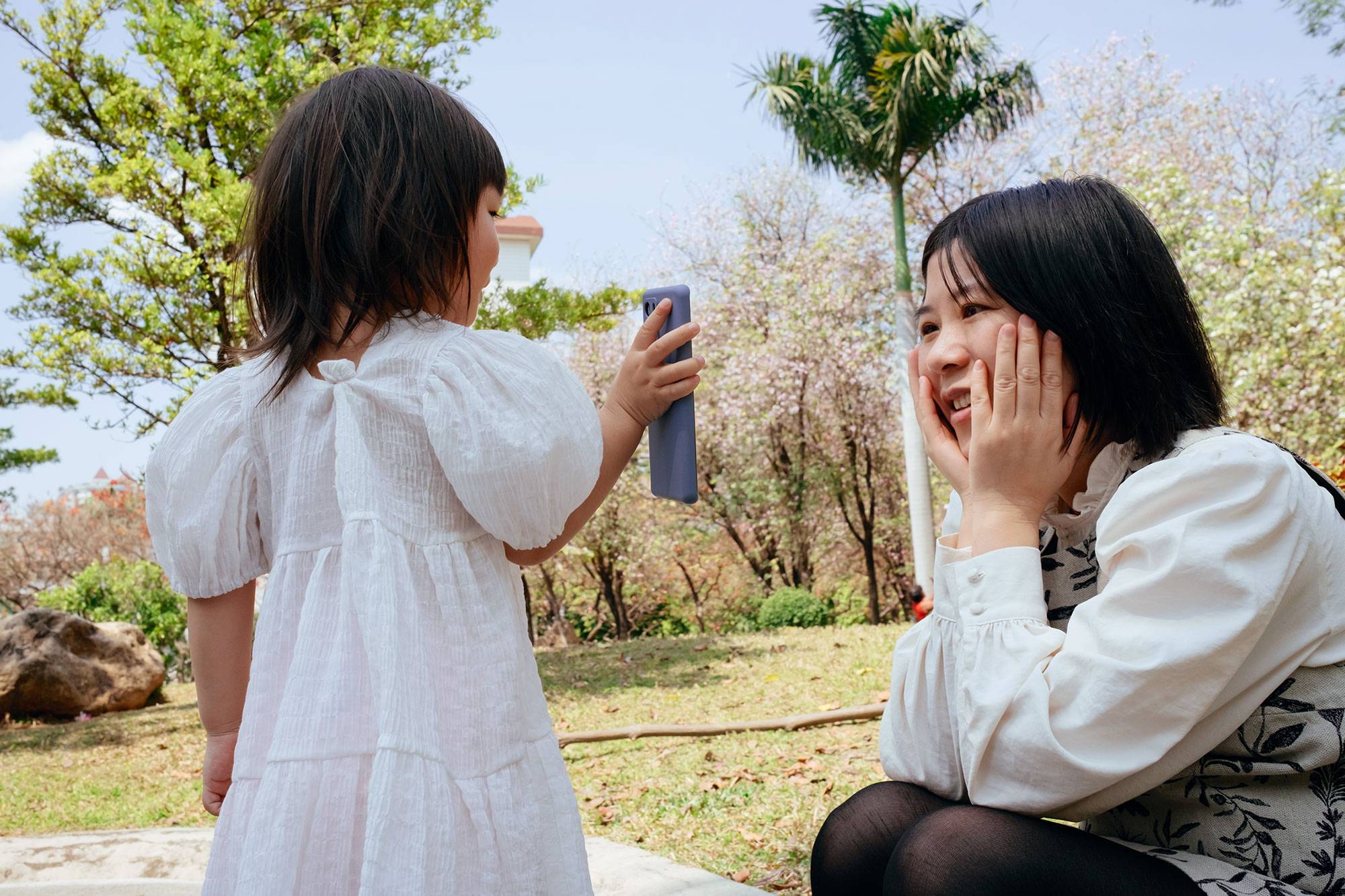 Little Girl Taking Pictures Of Mother With Cell Phone