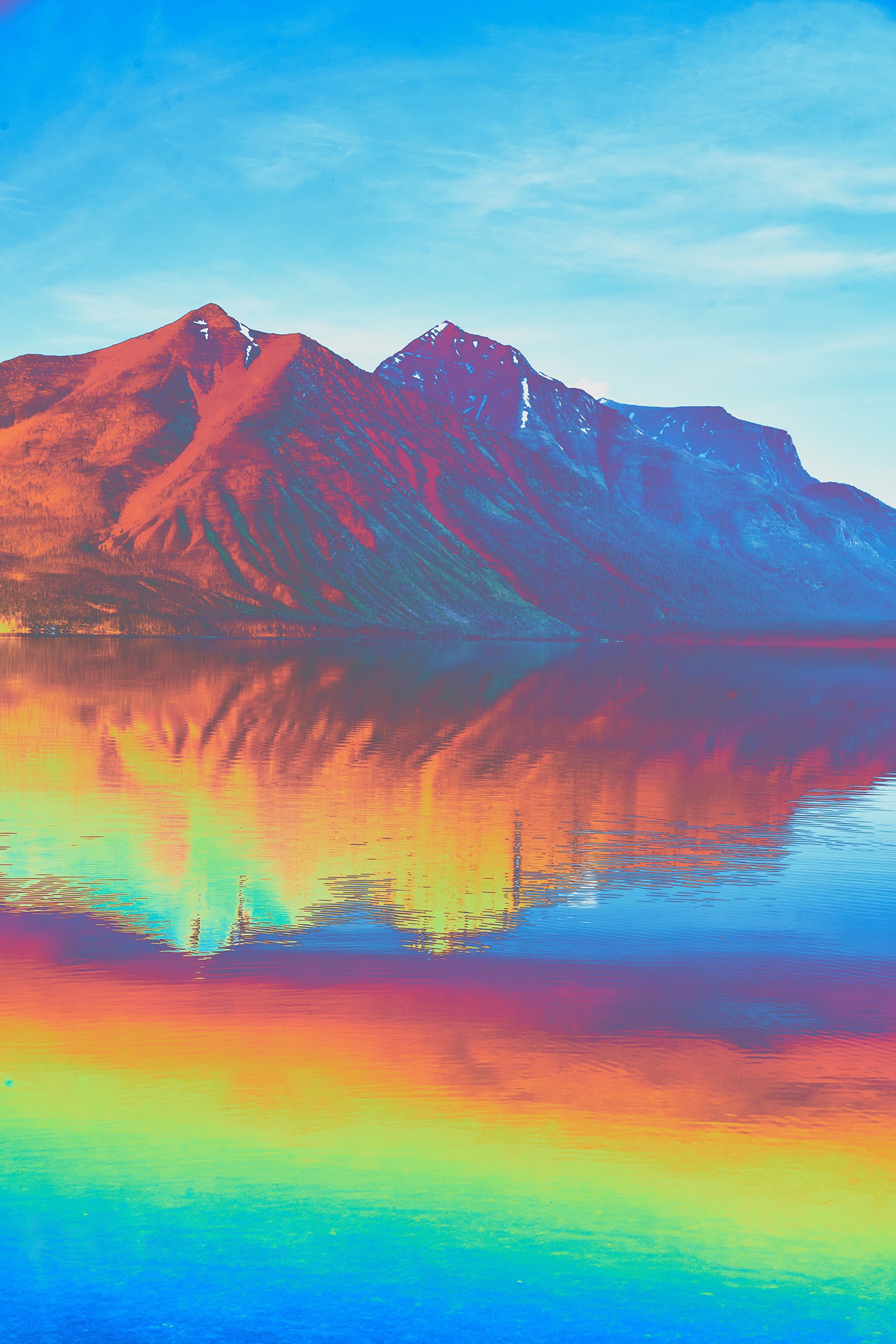 Digital vibrant rainbow color glitch over a lake and mountain landscape
