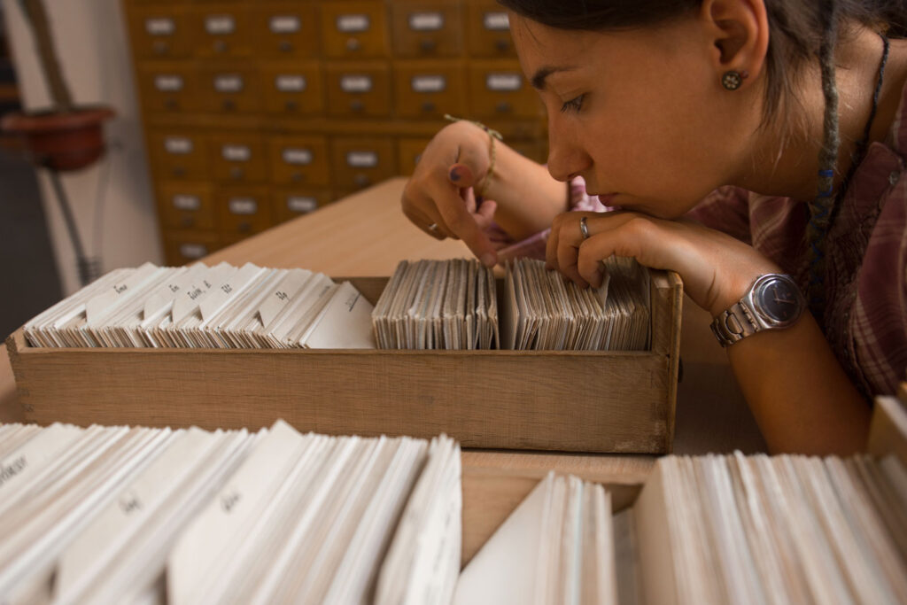 Close up of young female student searching through library index