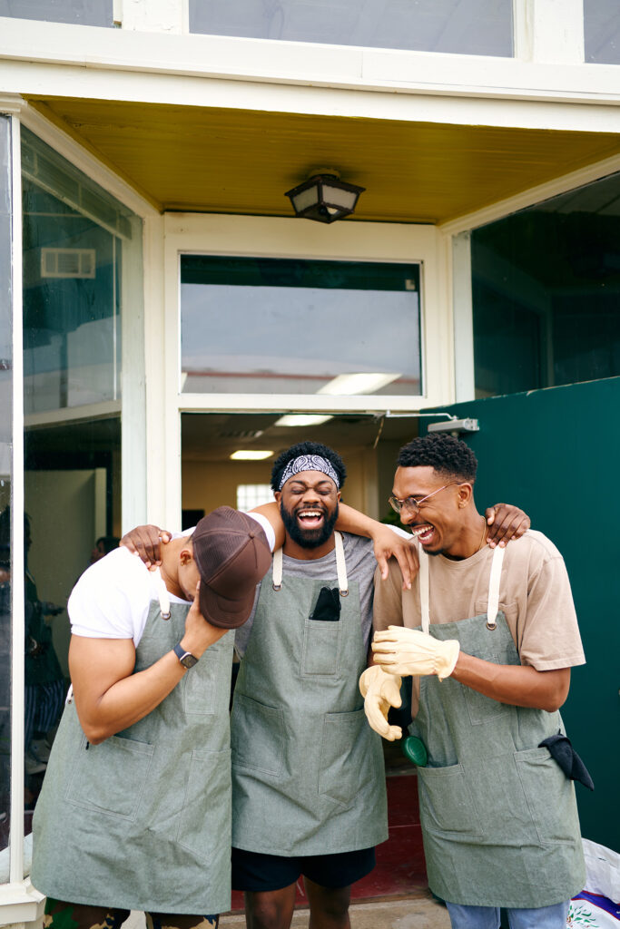 Portrait of happy workers laughing at the door of a plant nursery in Dallas. Texas