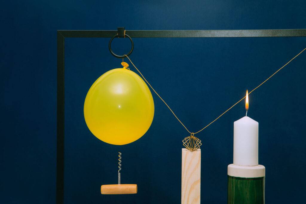 The set with a yellow balloon hanging over a corkscrew, which will burst when the candle burns out