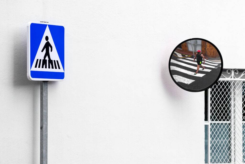 Crosswalk Signal And Pedestrian Crossing In Mirror.