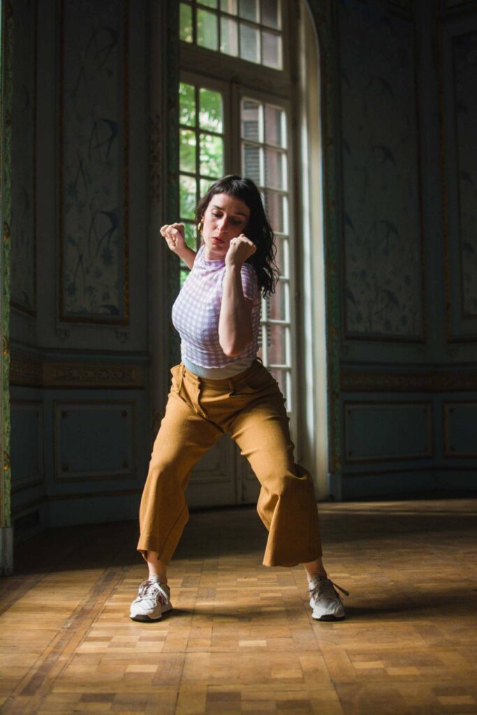 Woman dancing in a beautiful french style architecture room with blue design wallpaper.