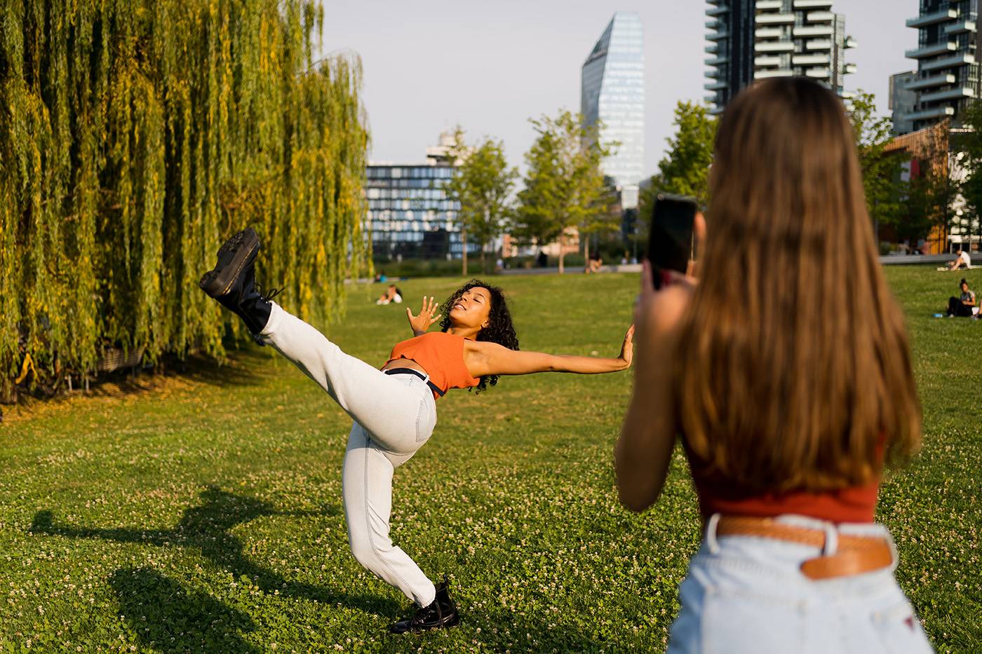 A Woman Filming Her Friend Dancing In Nature