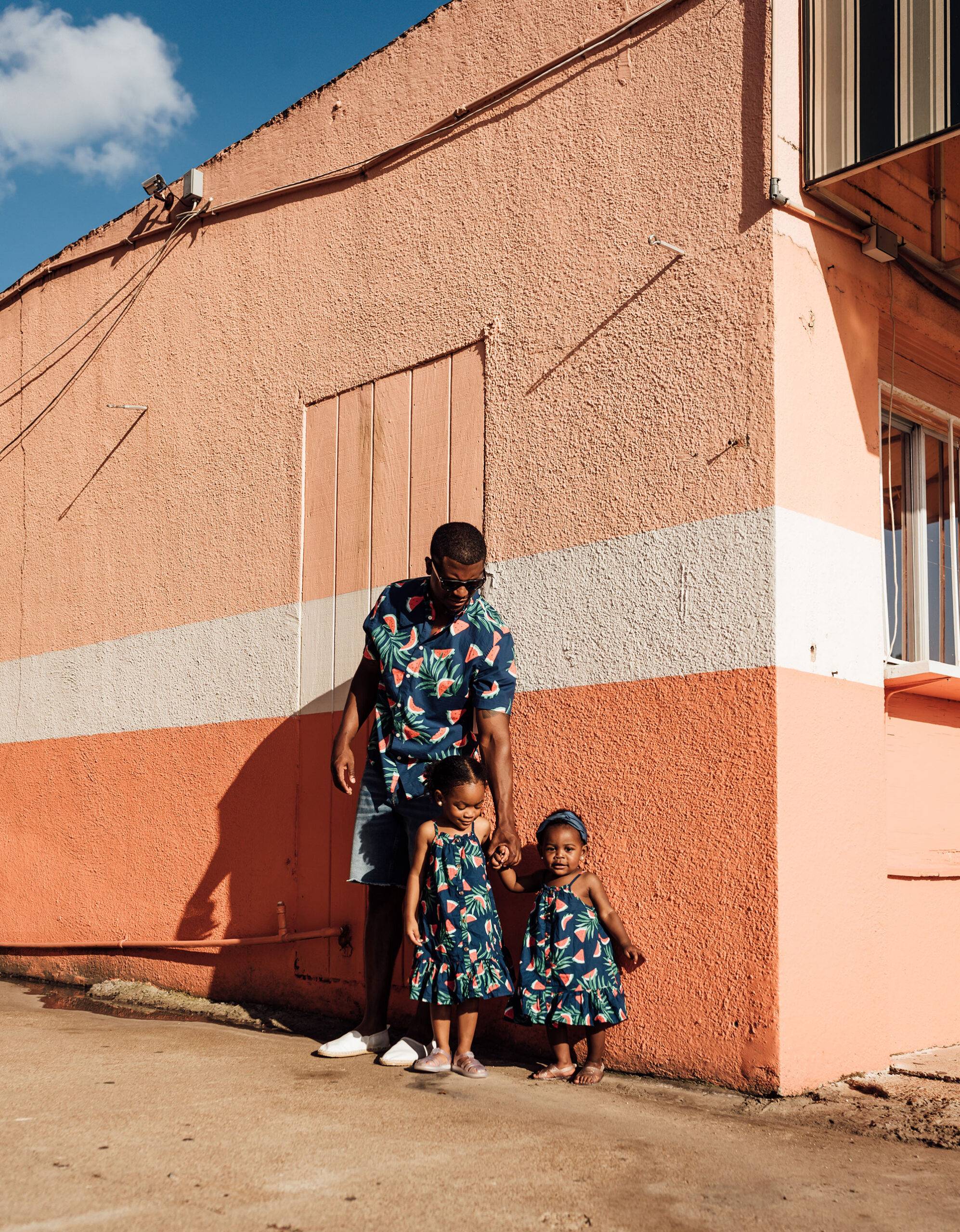 Black fater weating mathcing outfits with daughter taking lifestyle portraits