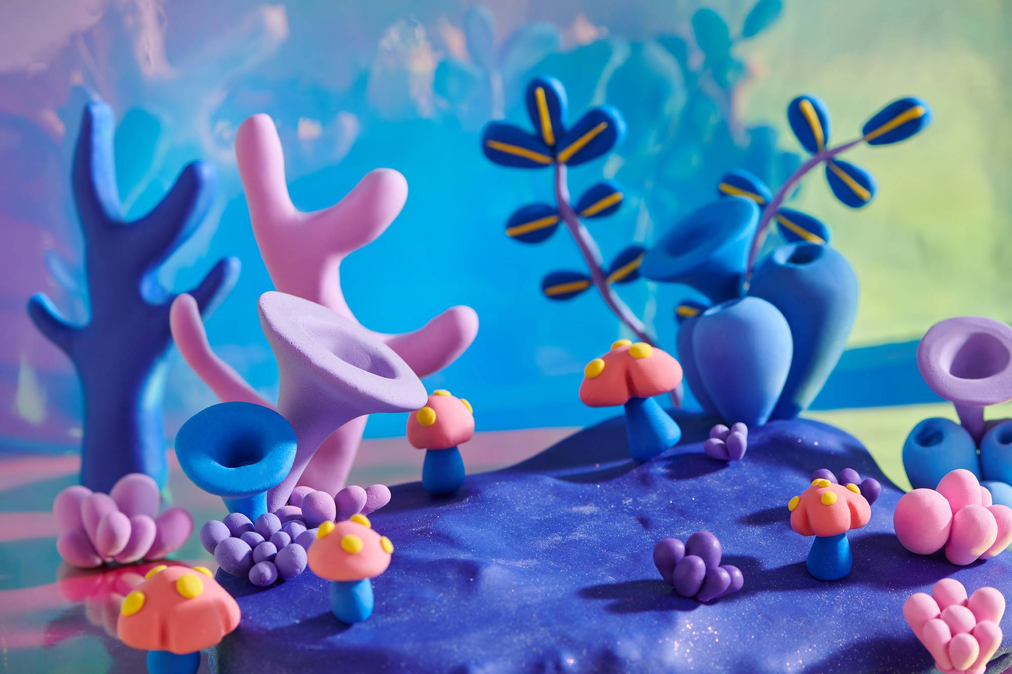 Underwater world with coral reefs and from colored plasticine on the background of blue sea