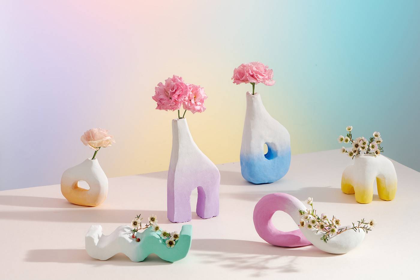 Vases Of Different Shapes Made Of Ceramic Stand On The Pedestal Against The Color Background Buttercup flower in ceramic vases and white cylinder podium on light background