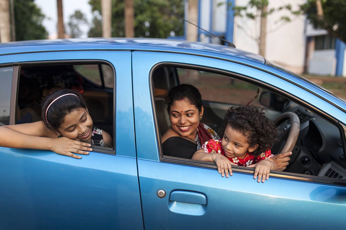 Indian Woman With Ethnic Sari Dress Sit Inside A Car With Two Girls