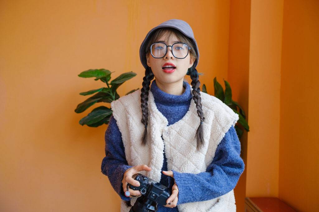 Young Asian female photographer holding camera