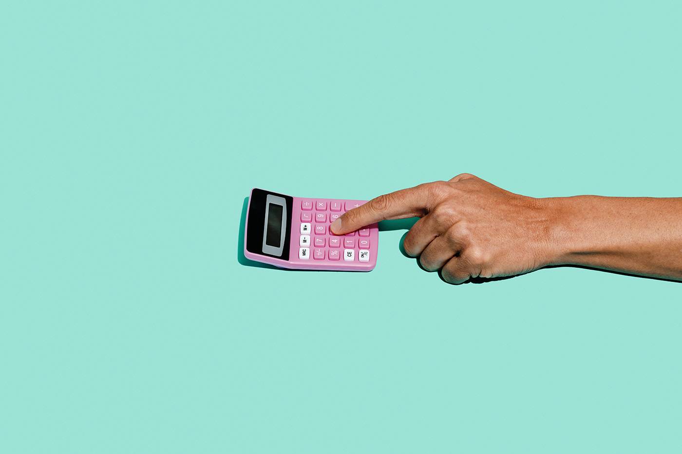 a young man uses a pink electronic calculator on a blue background