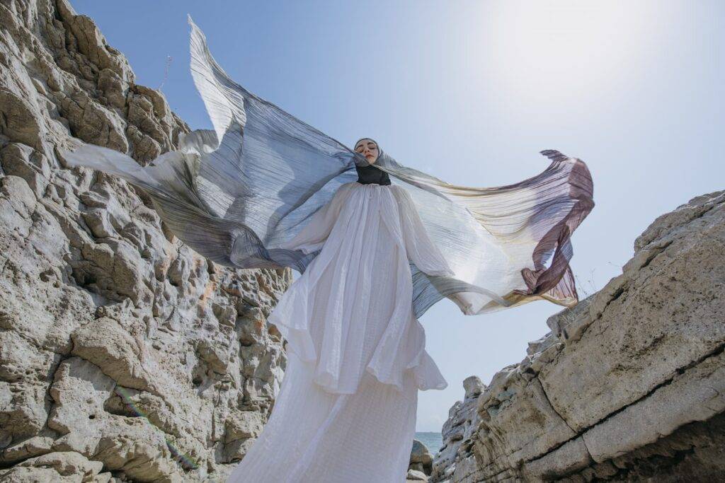 Young modern woman wearing colorful Hijab blowing in the wind.
