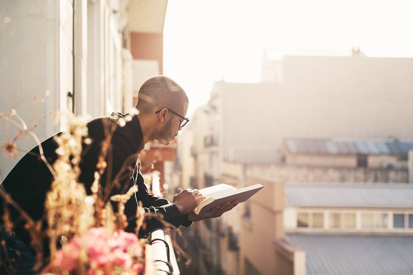Latin Man In The Balcony Reading A Book At Sunrise.