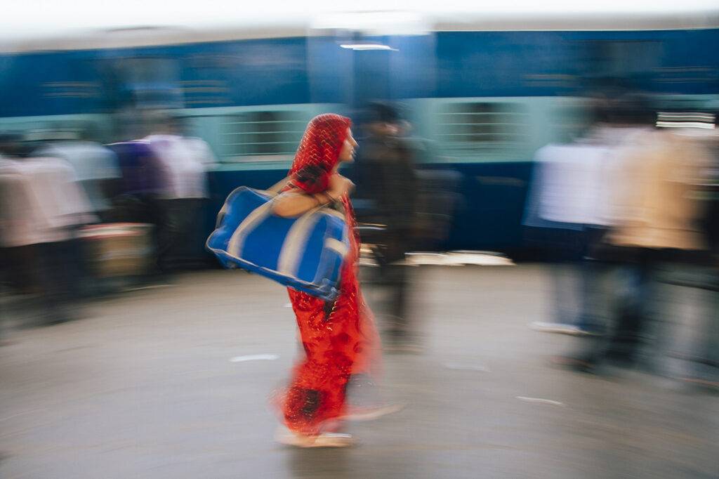 A Woman In A Hurry At A Train Station In India.