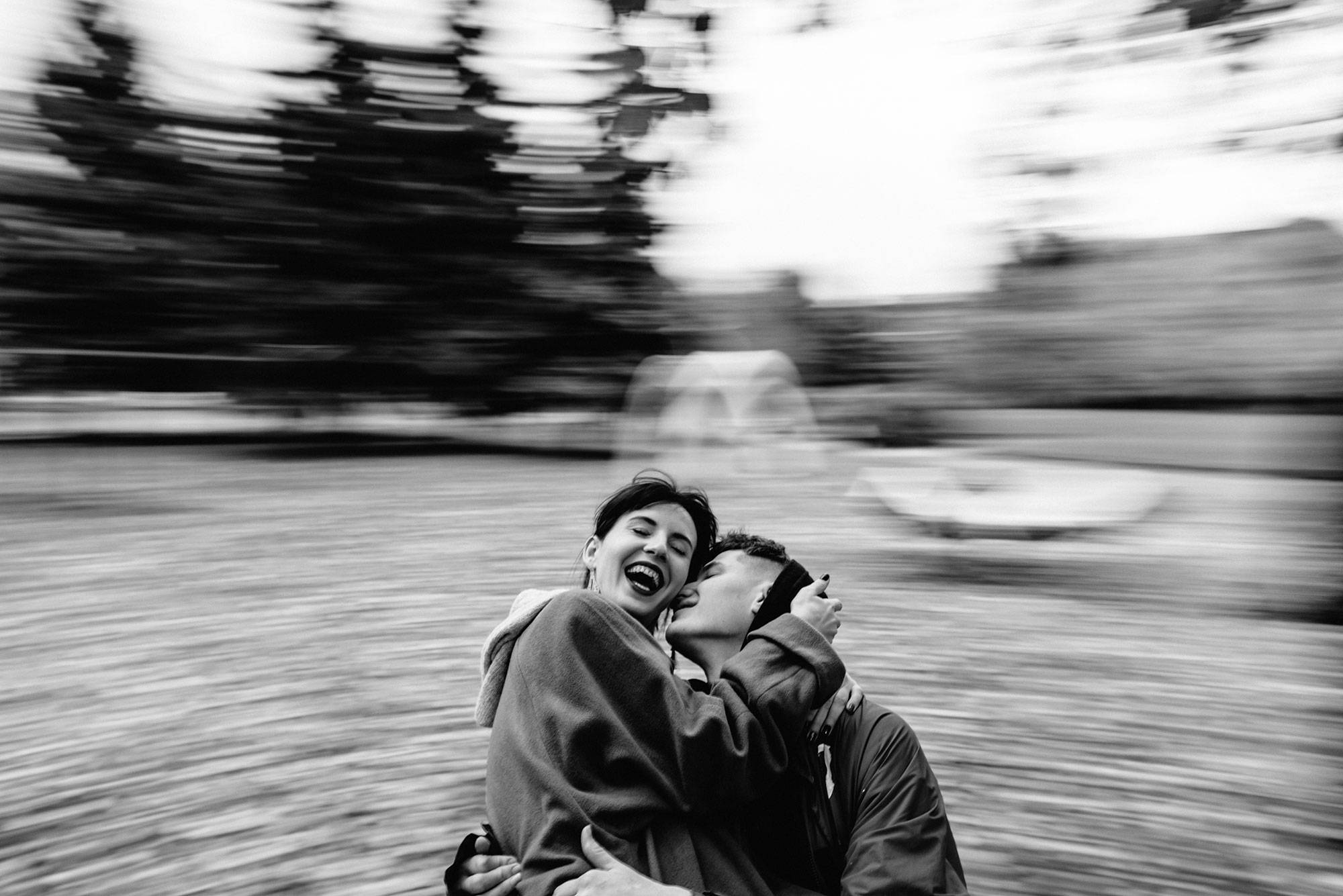 Young Couple Hug And Kiss On The Merry-Go-Round Black and white portrait of young couple in love