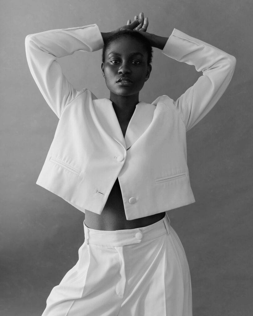 Trendy Black Woman In White Suit In Studio