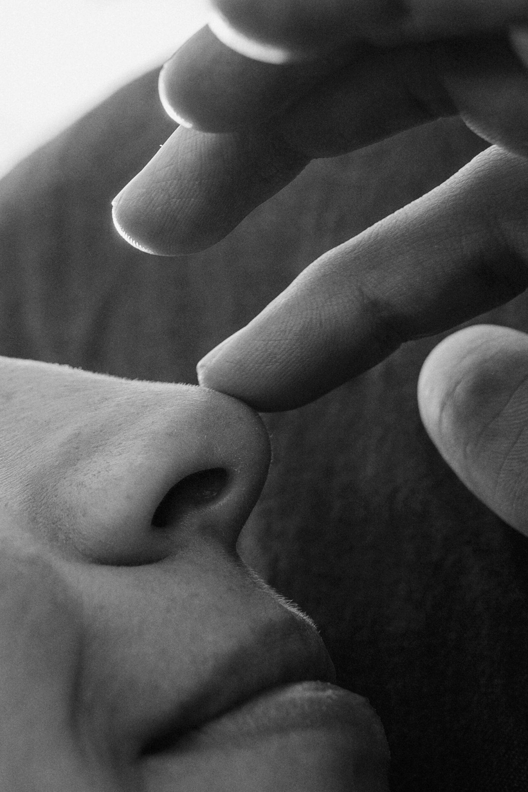 Black and white Close up photo of finger touching female nose