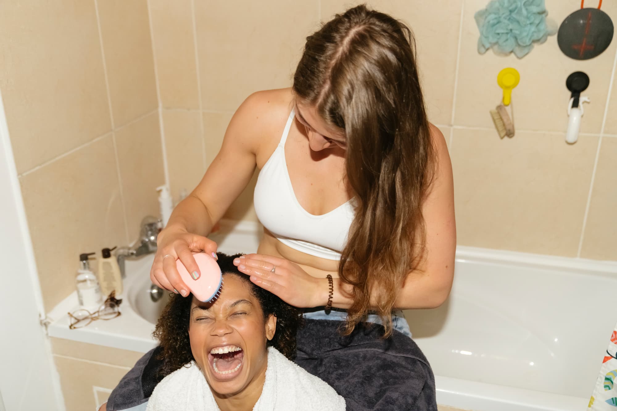 A Woman Brushes Female Friend Hair