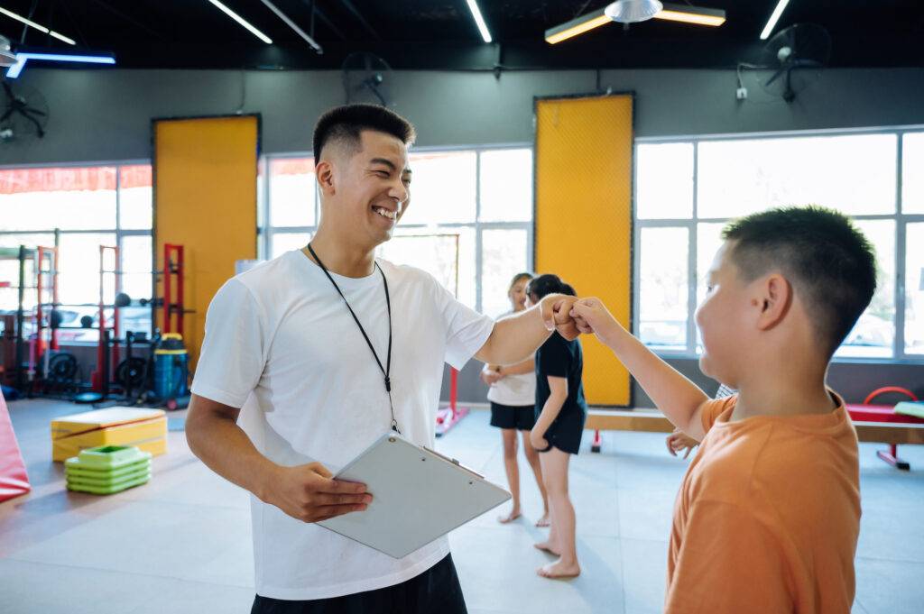Asian Coach Instructing Young Kids