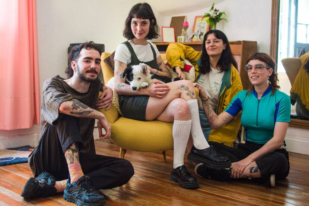 Group of artist sharing a studio and hanging out with the studio dog, a border collie pup. They are a modern team of tattoo artists.