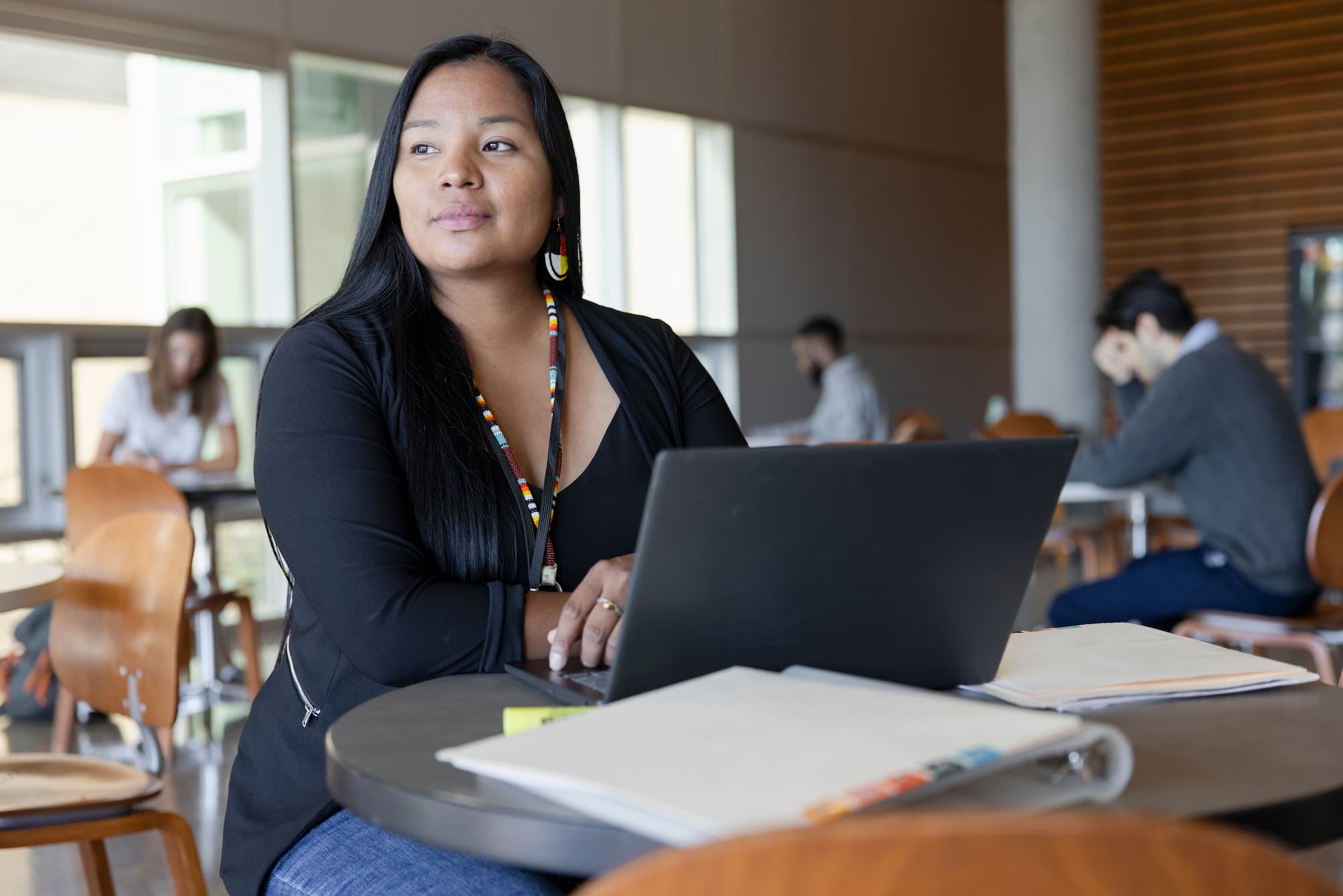 Thoughtful Female College Student Studying At Laptop In Library.