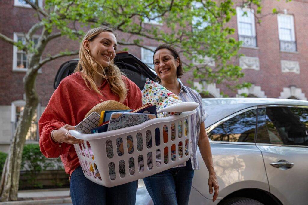 Happy Mother And Daughter Moving In To University Dorm Room Together