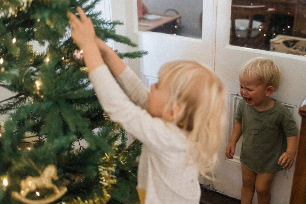 Toddler Cries As Sister Decorates Christmas Tree