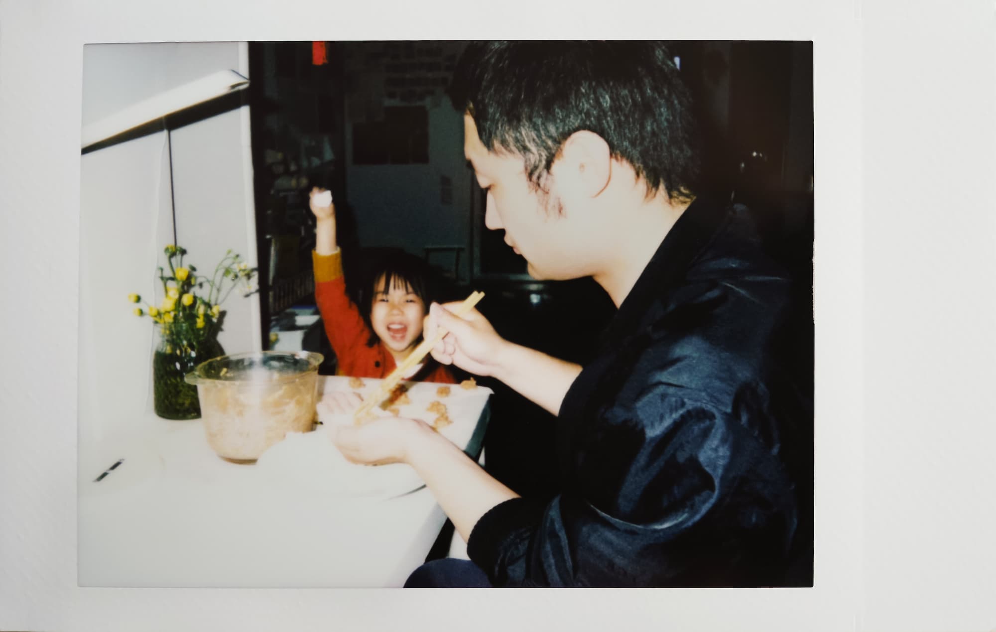 Asian father and 4-year-old daughter together in the home to make dumplings, the baby proudly held up her own dumplings