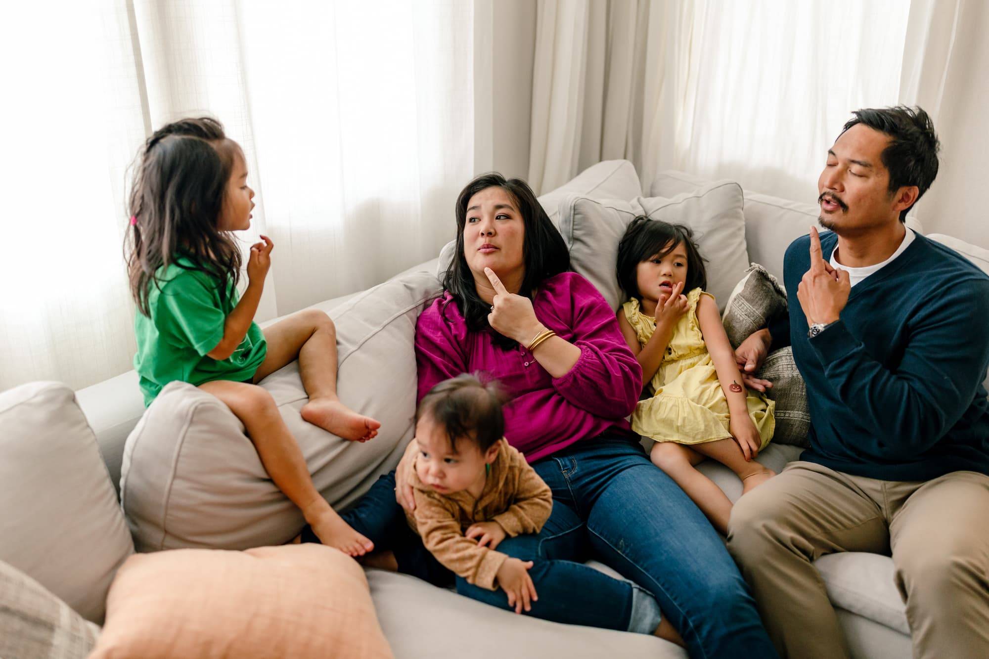 Deaf mom with hearing dad and 3 children communicate using sign Language. They are teaching daughter new asl sign.
