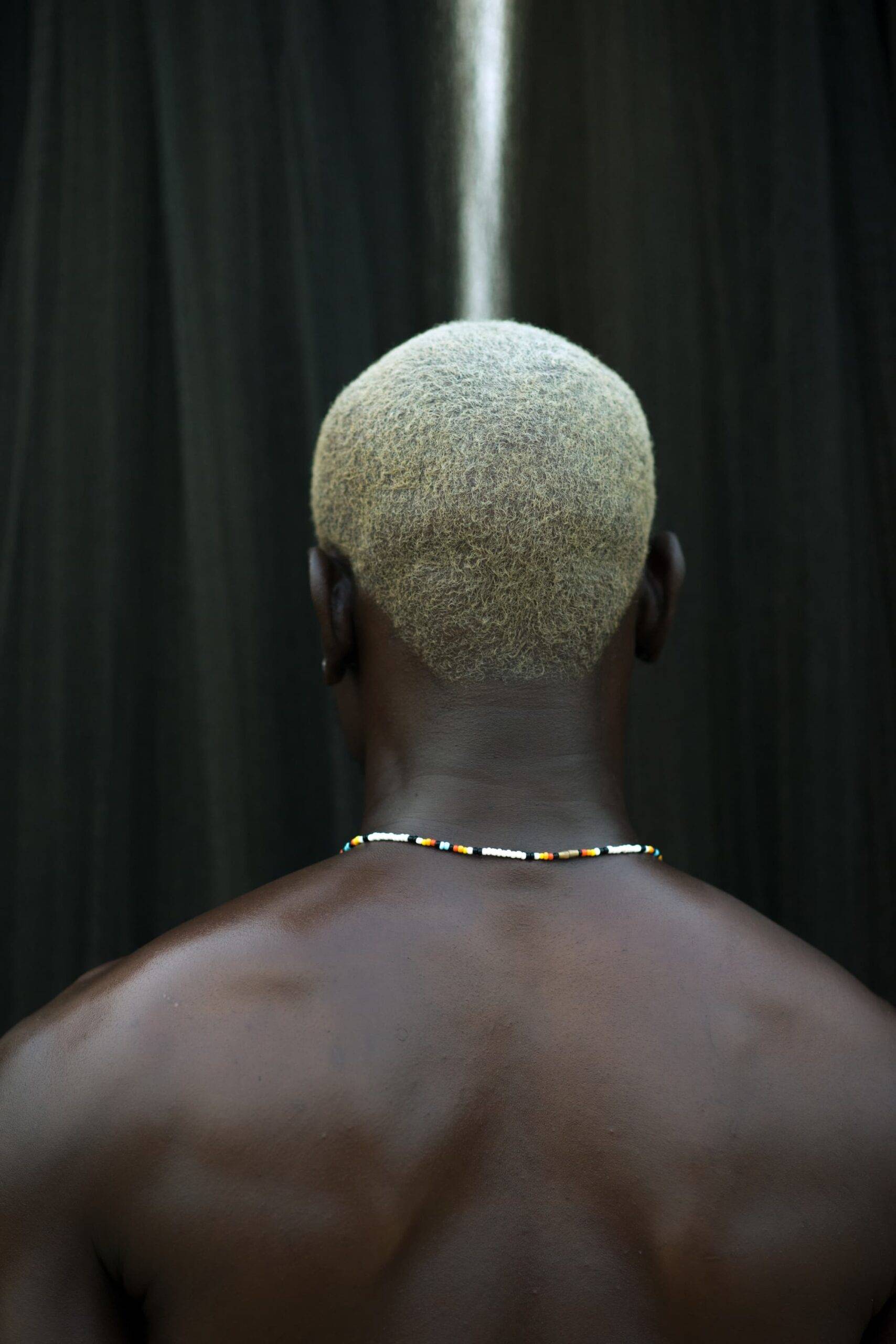 A dark skin model with a blonde hair in a river.