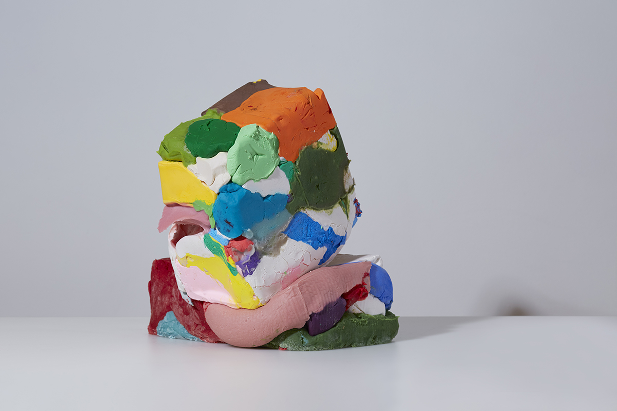 A large moulded pile of multicoloured children's modelling dough. It is isolated and has copy space. It is abstract.