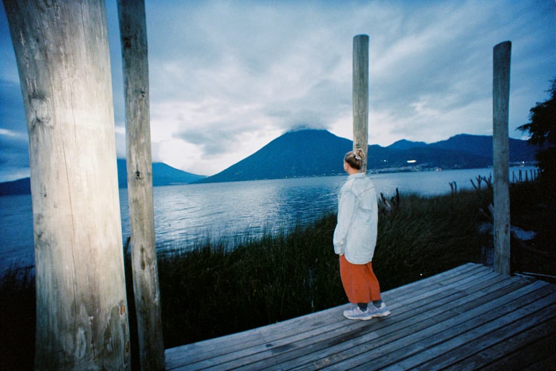 Evening light woman watching sunset looking towards a lake and volcano in the background
